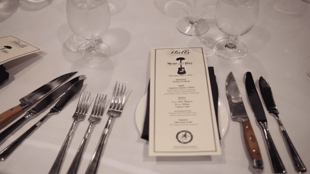 Elegant table setting with a detailed menu card and multiple utensils.